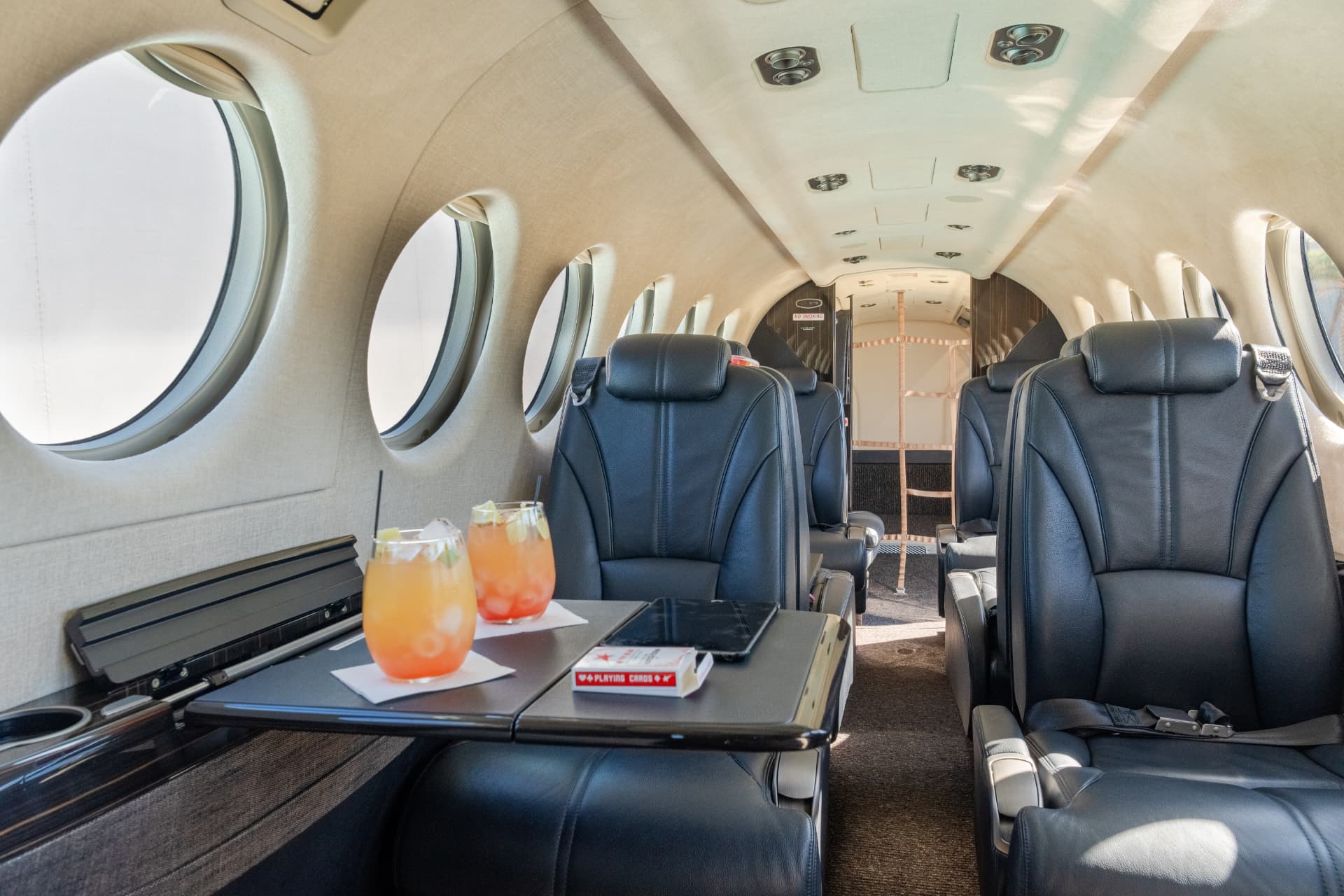 King Air cabin interior with leather club seating and drinks on the table